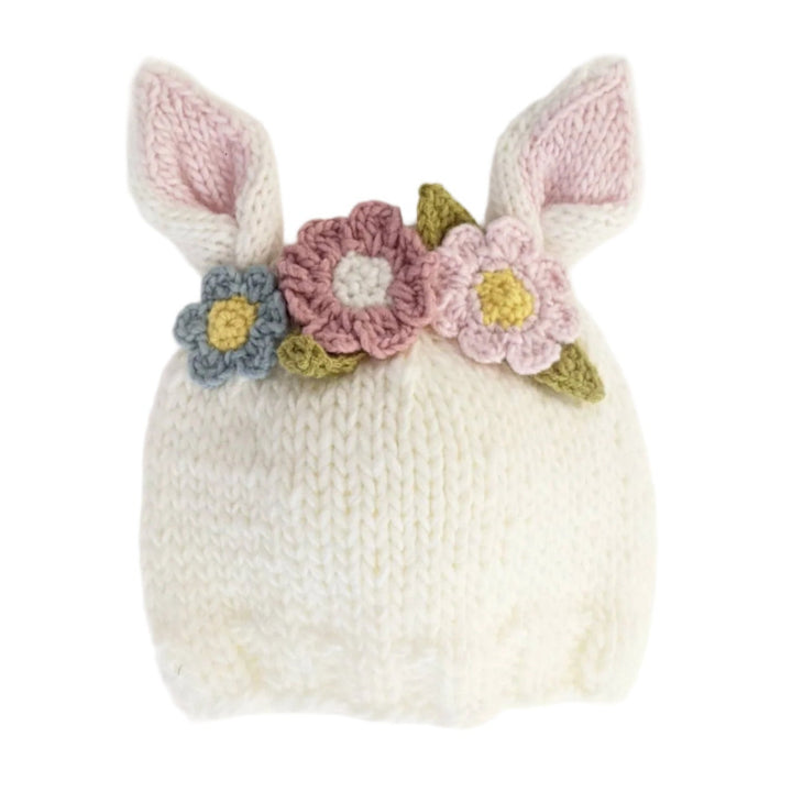 Knitted baby hat with bunny ears and flowers on a white background